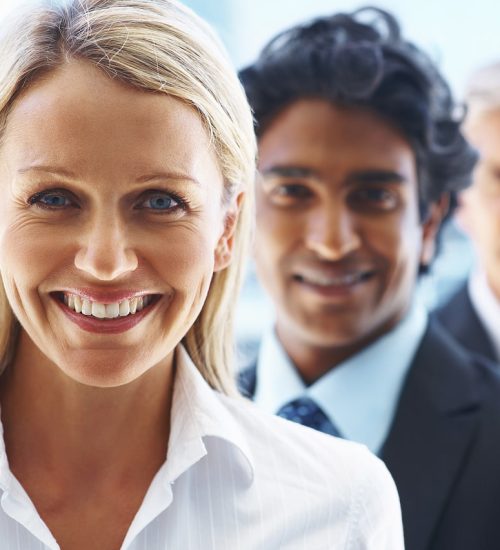 Pretty business woman with associates behind her